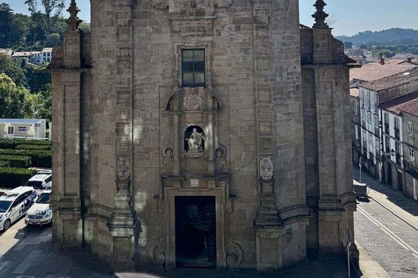 A historic stone building with a statue, a door, and a window. 2