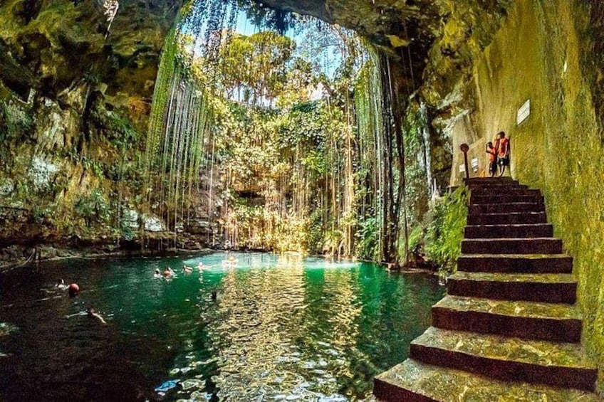 A natural pool with clear water, surrounded by lush greenery and a staircase leading up to a higher level. 4
