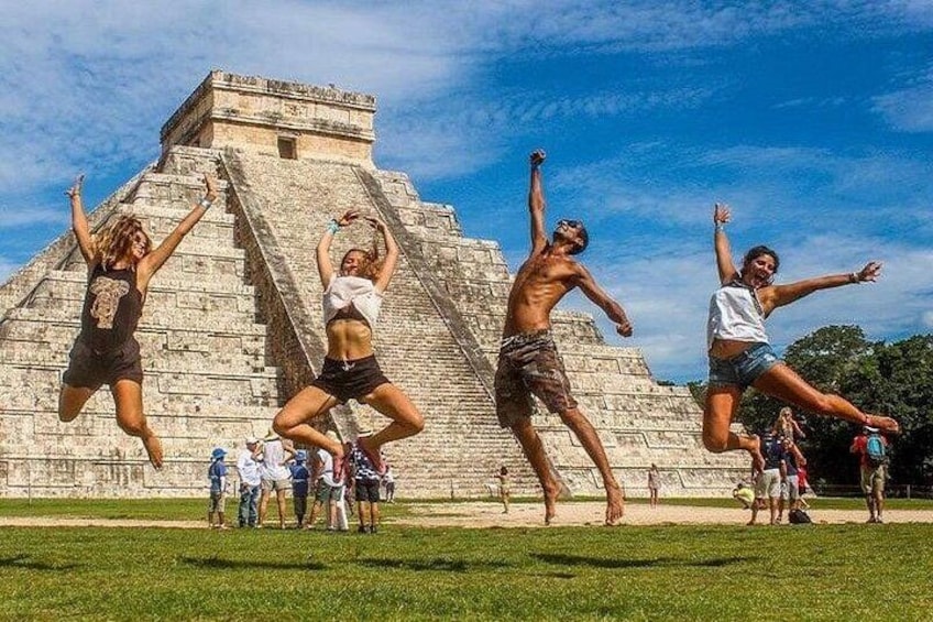 People jumping in front of a large pyramid. 5