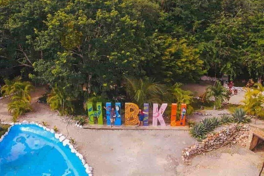 A pool, colorful letters spelling 'HIKING,' and lush greenery. 3
