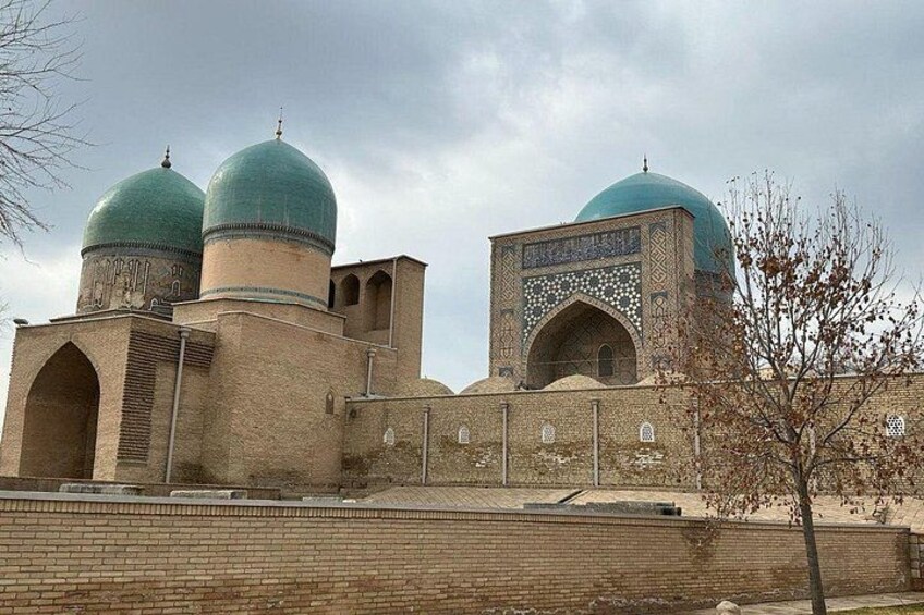 A mosque with two green domes and a minaret. 2