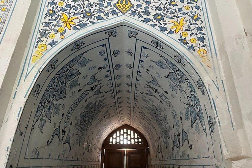 An arched doorway with intricate blue and yellow floral patterns. 3