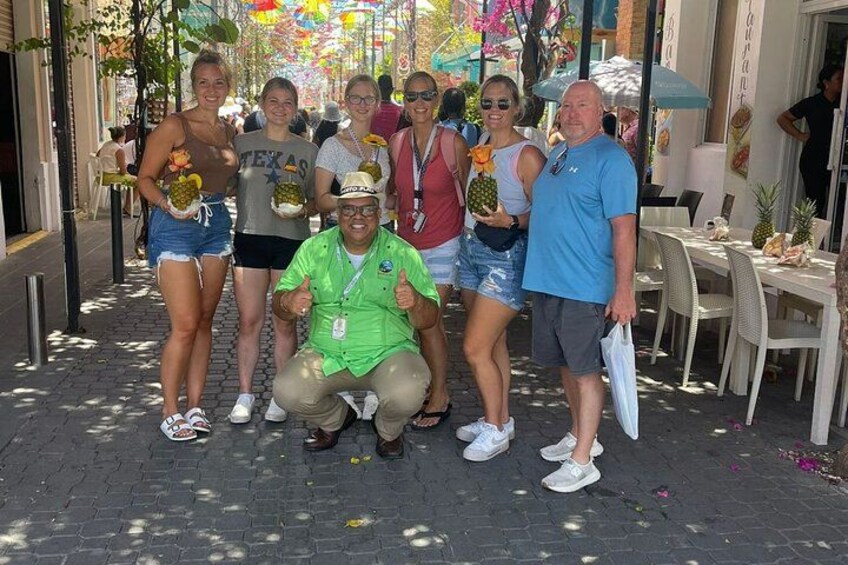 Un grupo de personas posando en una calle adoquinada, con un restaurante al fondo. 5