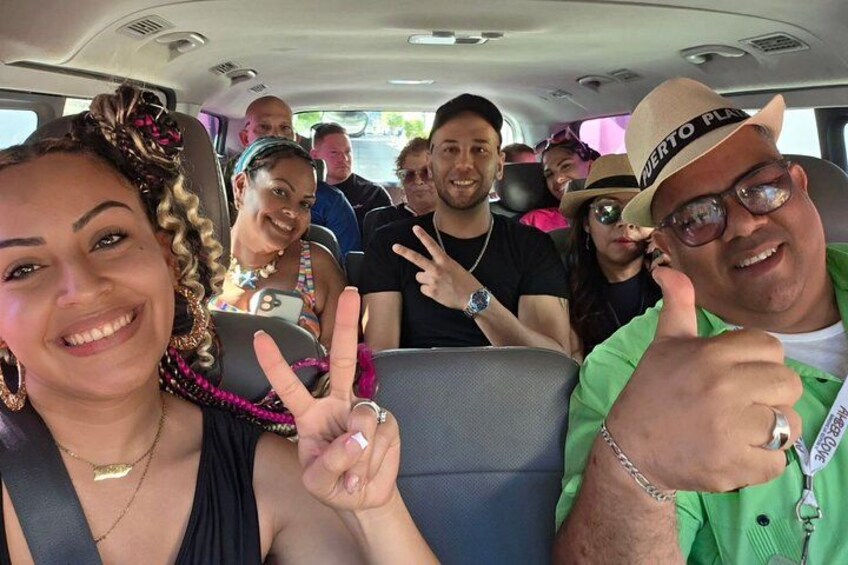 Un grupo de personas en un vehículo, algunas haciendo la señal de la paz y una persona levantando el pulgar. 2