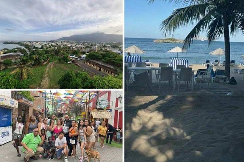 A coastal town with a beach, palm trees, and a group of people posing in front of a colorful building. 1