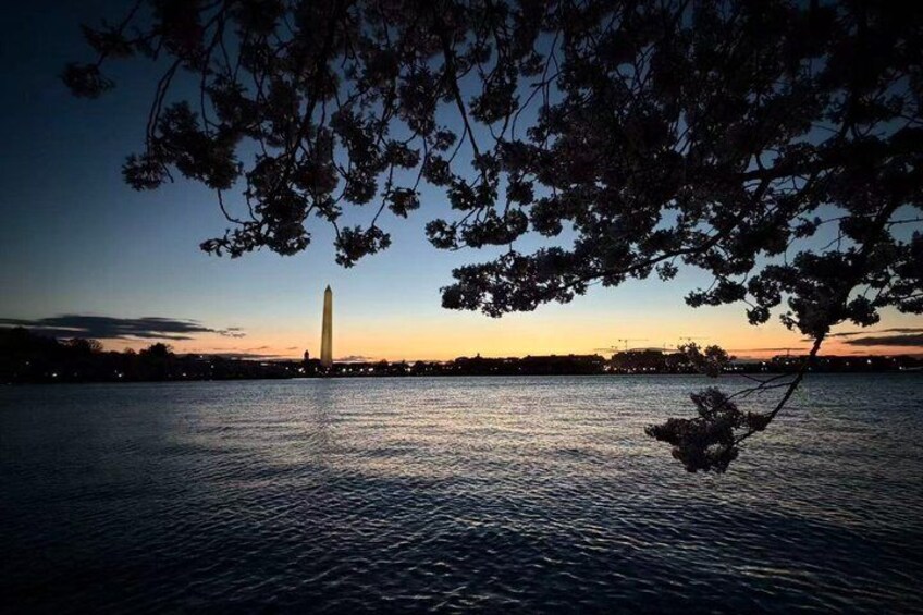 A sunset over a body of water with a prominent monument in the background. 3