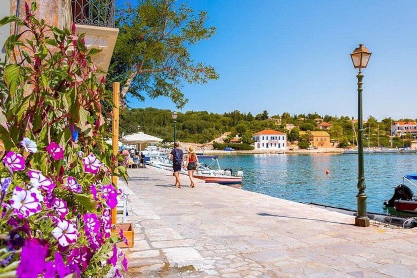 Une promenade en bord de mer avec des bateaux, un lampadaire et une personne qui se promène. 4