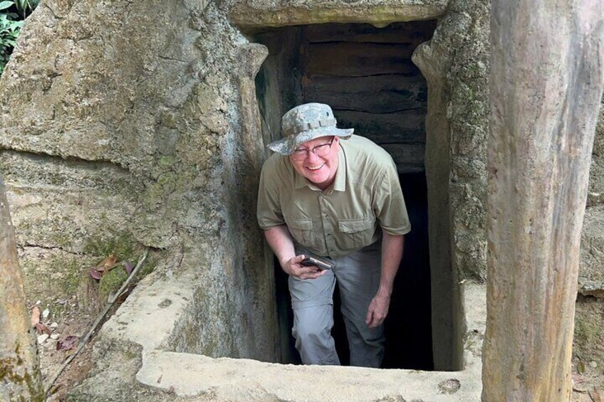 En man med hatt och skjorta som står i en dörröppning av sten. 3