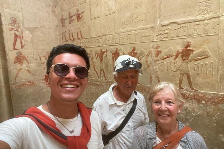 Three people standing in front of ancient Egyptian wall carvings. 5