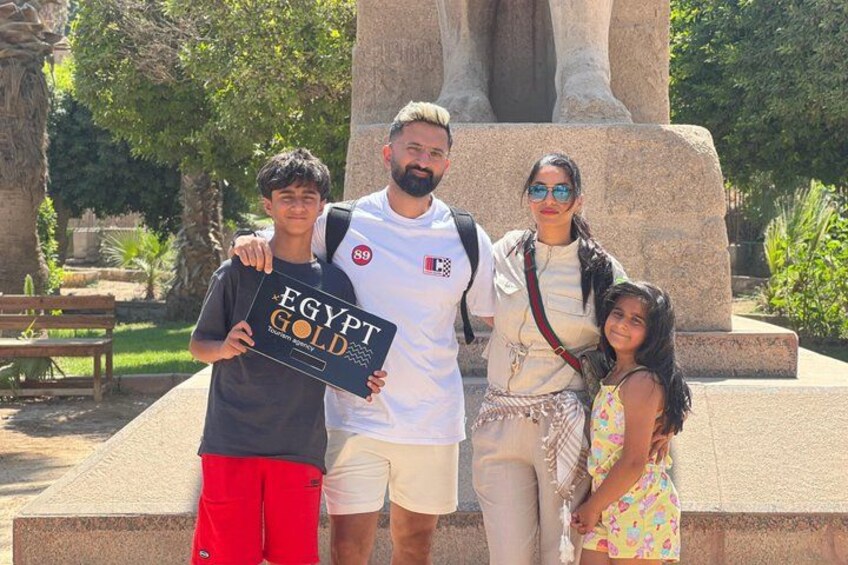 A group of people standing in front of a large stone statue with a sign that reads 'EGYPT GOLD.' 4