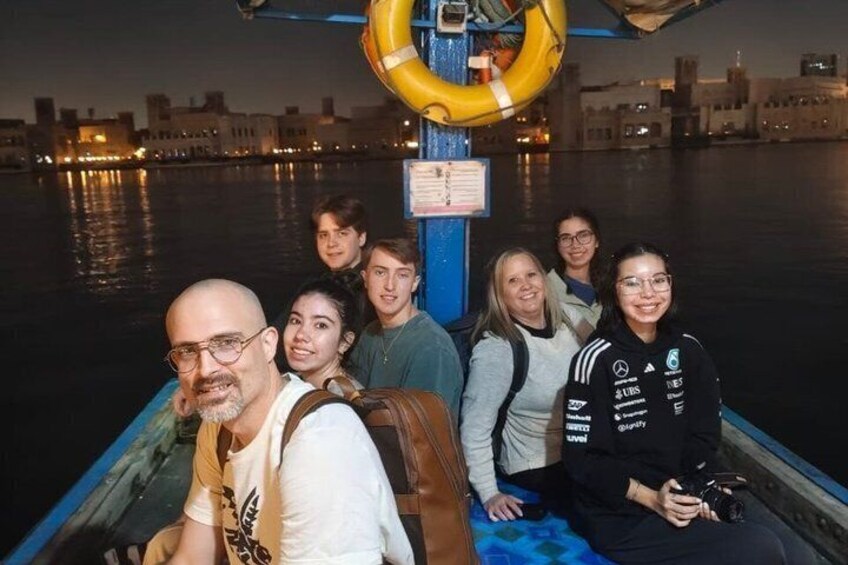 A group of people on a boat with a city skyline in the background. 2
