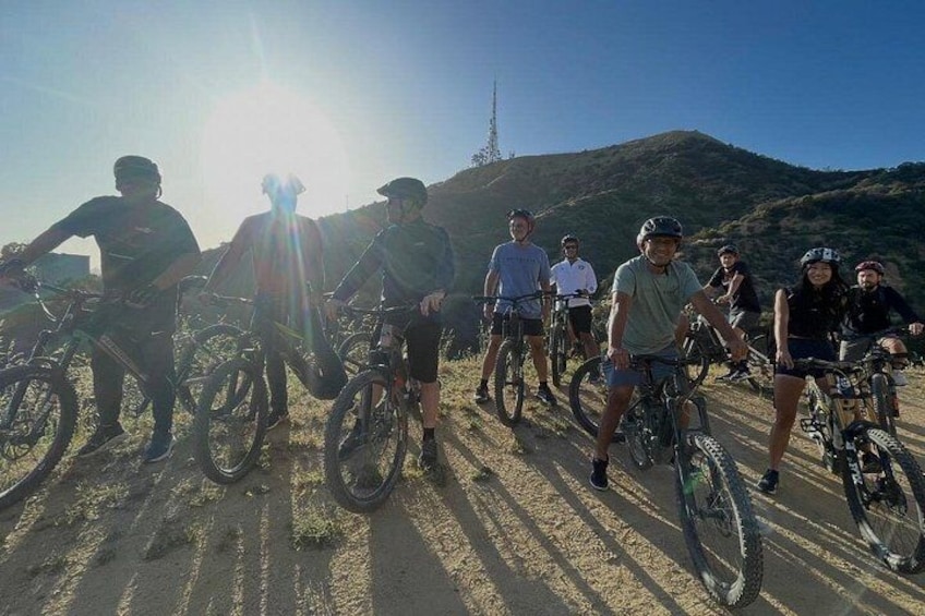 Un grupo de ciclistas en un sendero de tierra con una montaña al fondo. 2