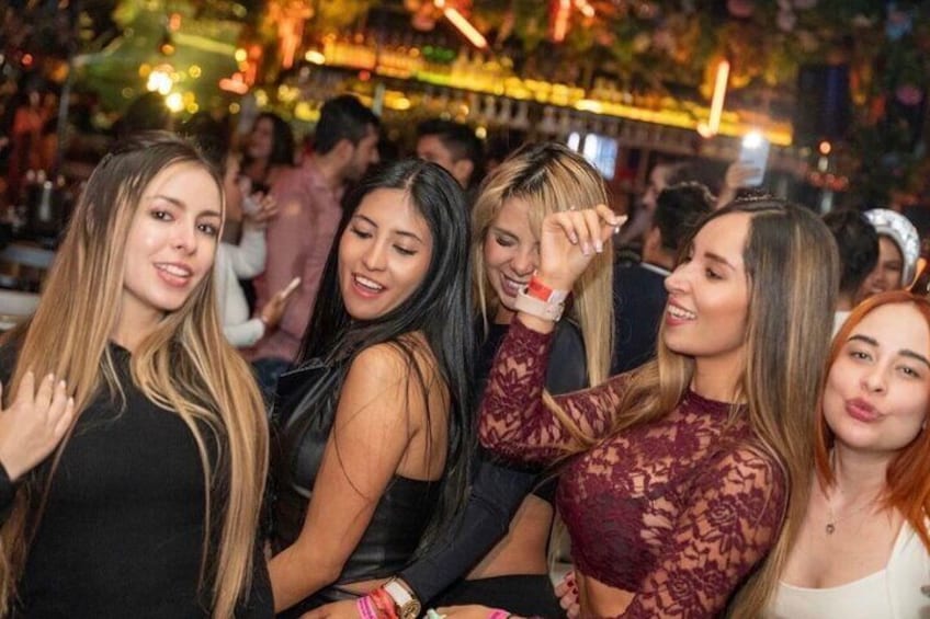 A group of people at a social event with indoor lighting and decorations. 2