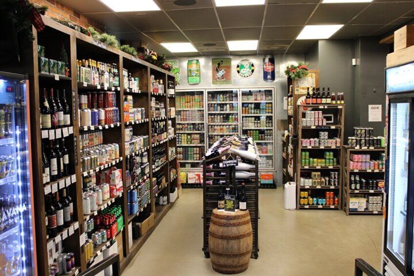 En alkoholbutik med hylder fyldt med forskellige flasker og dåser. 5