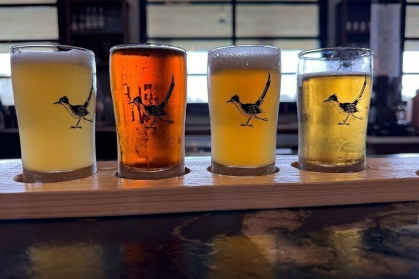 Four glasses of beer with bird designs on a wooden bar. 5