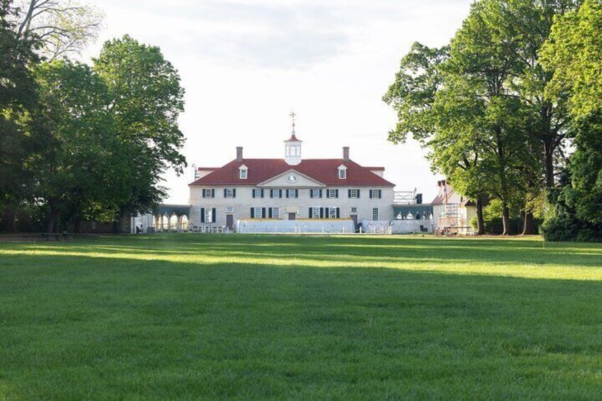 A large white building with a red roof, surrounded by a well-maintained lawn and trees. 4