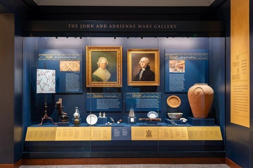The John and Adrienne Mars Gallery with historical artifacts, framed portraits, and informational displays. 5