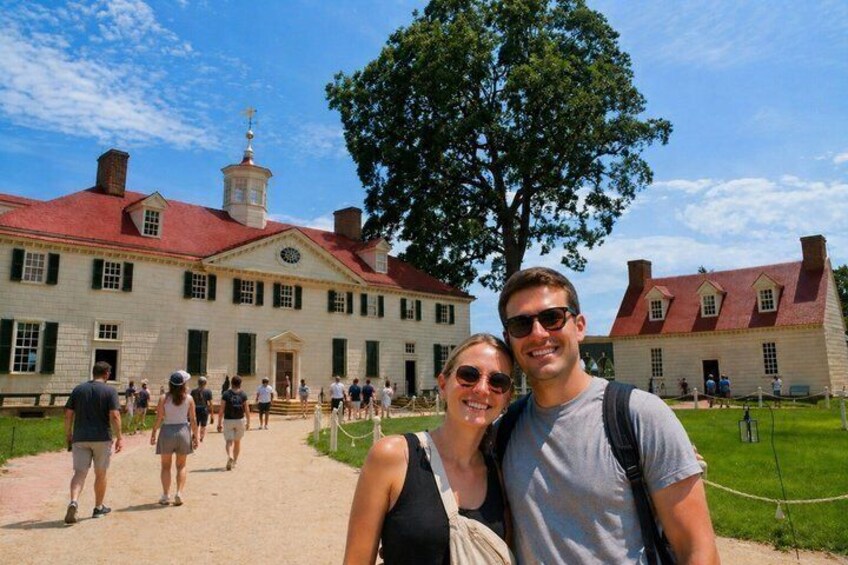 A historic building with a red roof and a large tree in front. 1