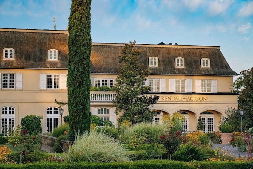 A historic building with the name 'Kendall-Jackson' on the facade, surrounded by lush greenery and a well-maintained garden. 3