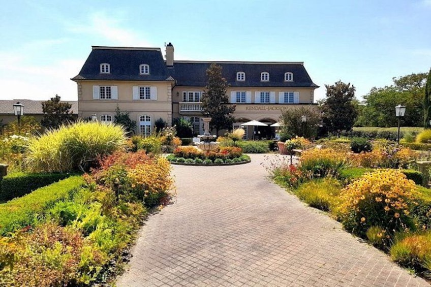 A landscaped garden with a paved pathway leading to a large building with a sign that reads 'KENDALL-JACK'S.' 2