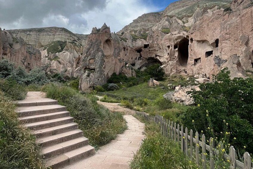 Un escalier en pierre menant au sommet d’une colline rocheuse, parsemée de formations ressemblant à des grottes. 4