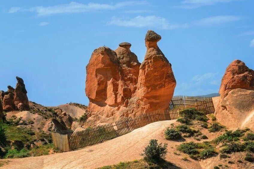 Paisaje desértico con formaciones rocosas destacadas y una cerca de madera. 1