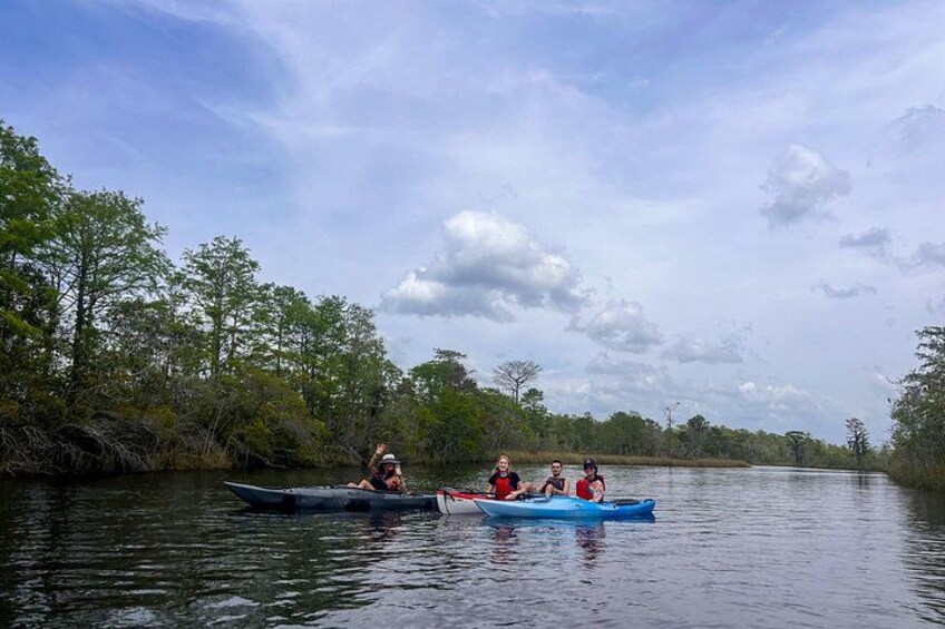 Tres kayaks en un río tranquilo rodeado de árboles frondosos. 5