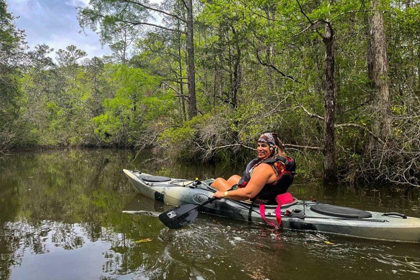 Una persona haciendo kayak en un río tranquilo rodeado de árboles frondosos. 4
