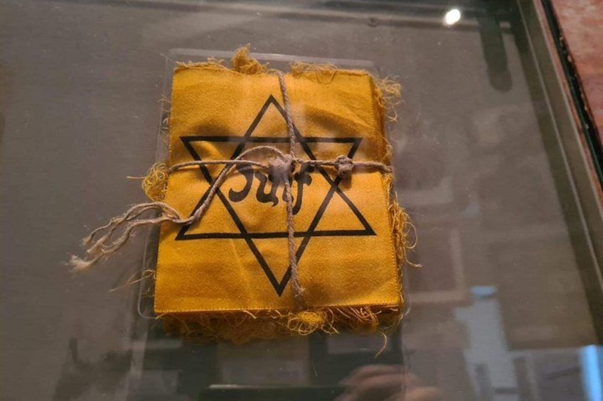 A yellow cloth with a Star of David and Hebrew letters tied with a string. 4