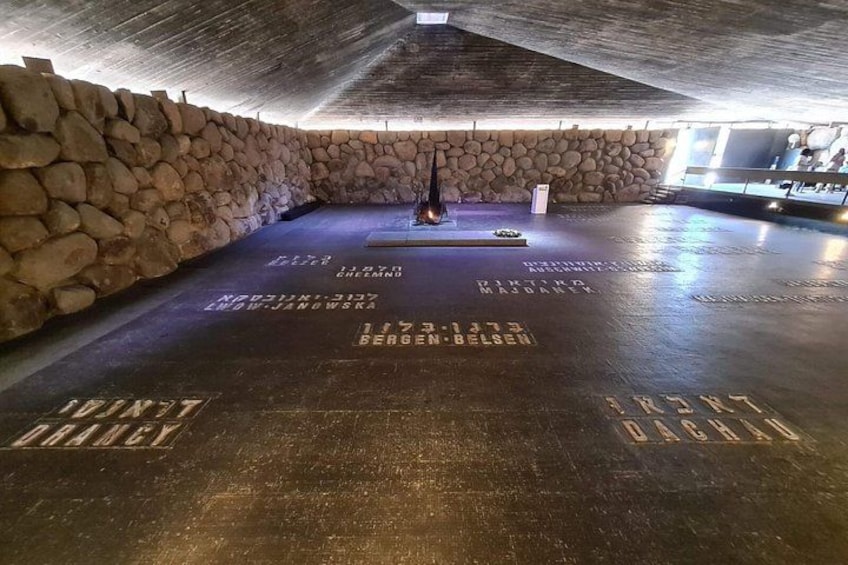 An underground chamber with stone walls and a central sculpture. 3