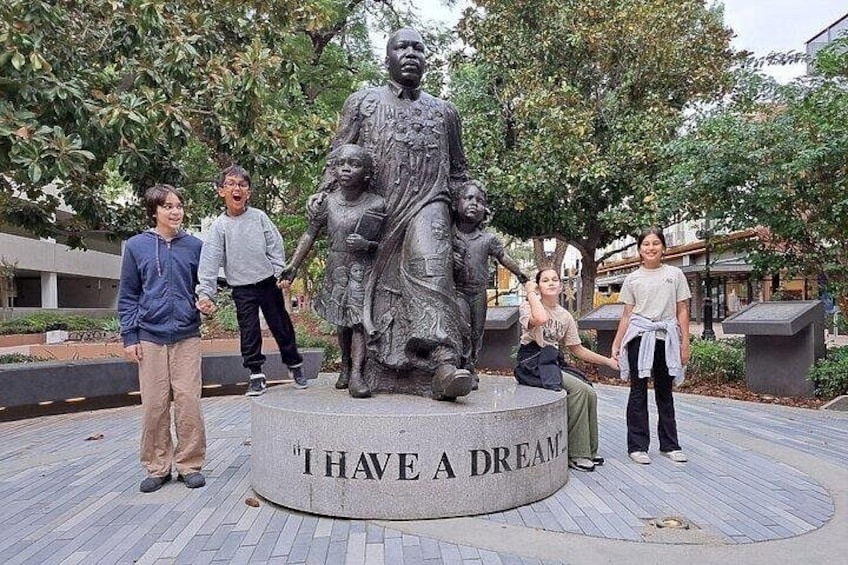 A statue with the inscription 'I HAVE A DREAM' surrounded by people. 1