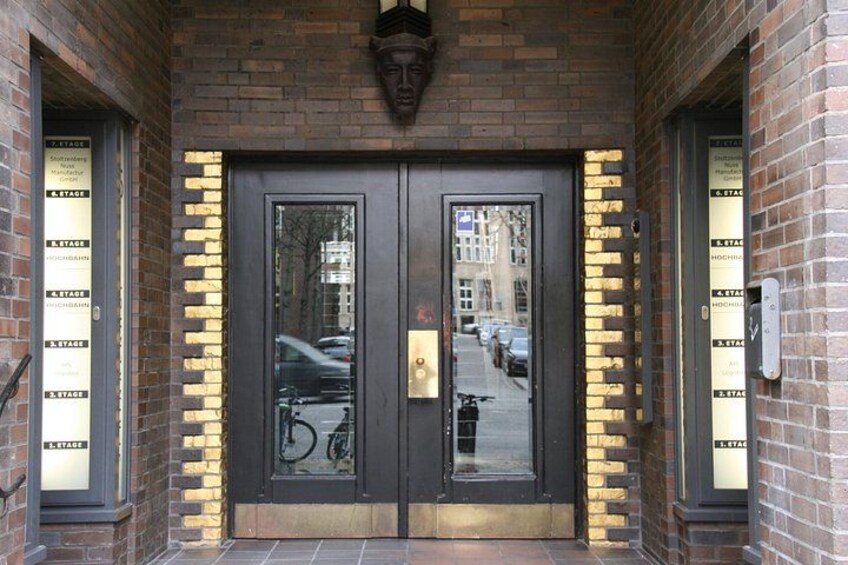 Une porte à deux battants avec des panneaux de verre, un mur de briques et un reflet de la rue. 5