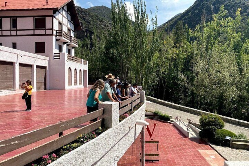 A group of people on a red-tiled terrace with a mountain backdrop. 4