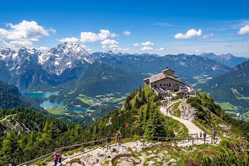 A mountain lodge with a scenic view of a lake and snow-capped peaks. 1