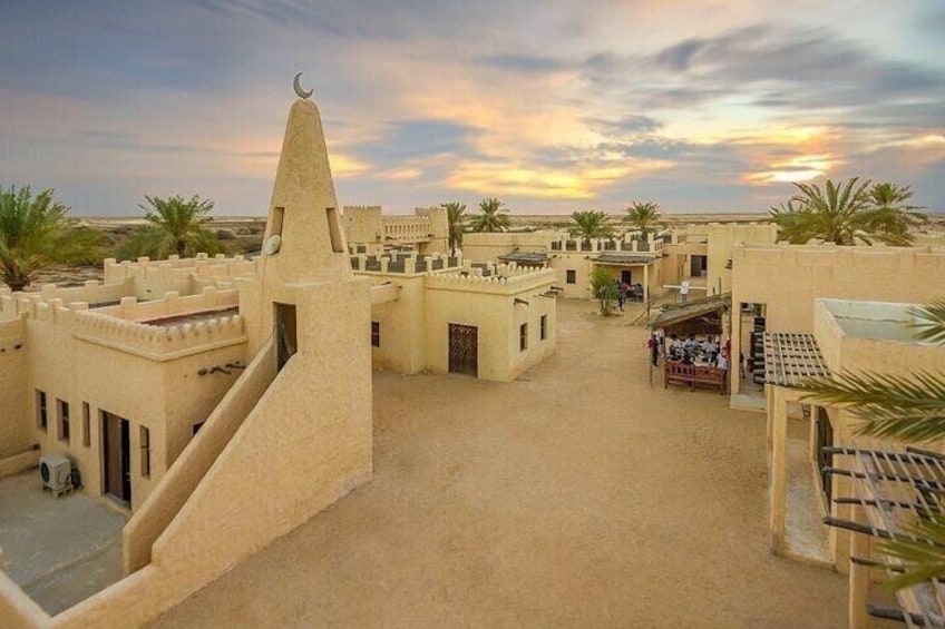 A desert town with traditional architecture, palm trees, and a clear sky. 2