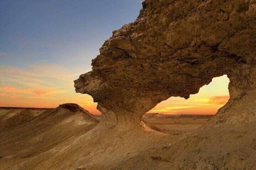 A rock formation with a natural archway. 1