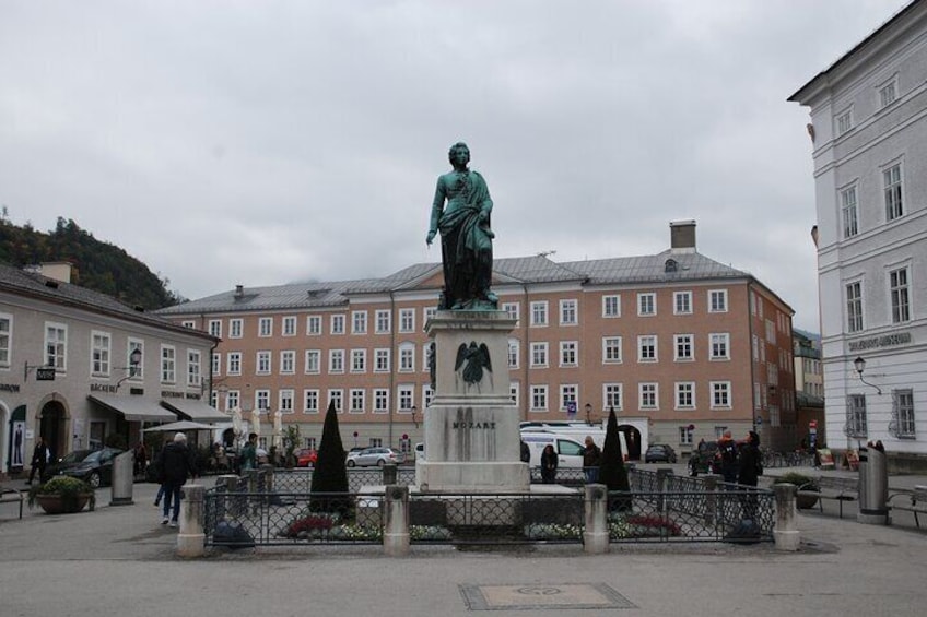 Una estatua en una plaza, con edificios al fondo. 5