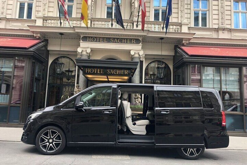 Un SUV negro estacionado frente a un edificio con un letrero que dice "HOTEL SACHER". 1