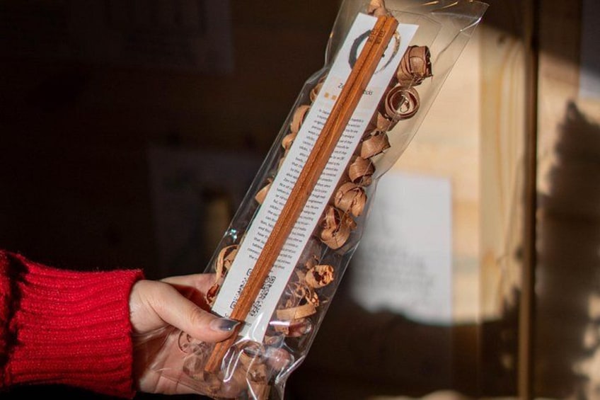 Une personne tenant un sac en plastique transparent contenant une barre de chocolat et quelques noix. 2