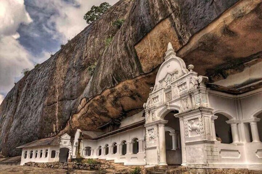 Un templo blanco con tallas intrincadas frente a una gran pared de roca. 3