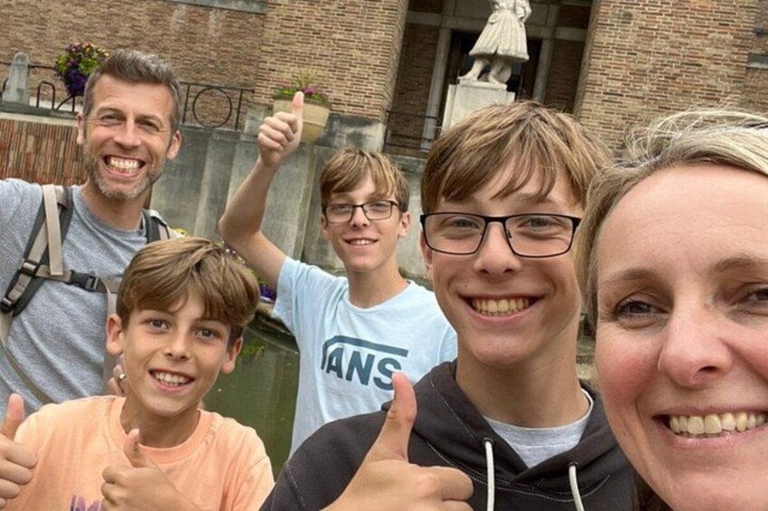 A group of people in front of a brick building with a statue. 5