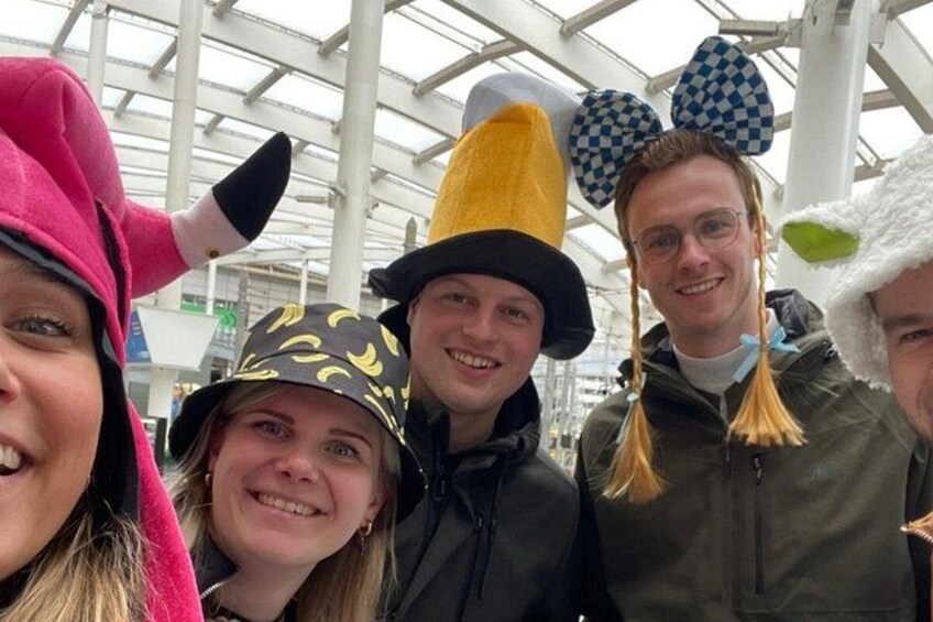 A group of people wearing various hats and a large indoor structure with a glass roof. 2