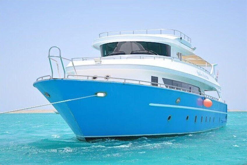 A large blue and white yacht on turquoise water. 1