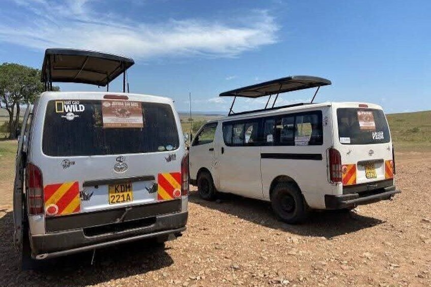 Dos camionetas blancas estacionadas en un camino de tierra bajo un cielo despejado. 1