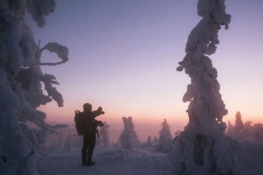 Une personne se tient debout dans un paysage enneigé, entourée d’arbres. 3