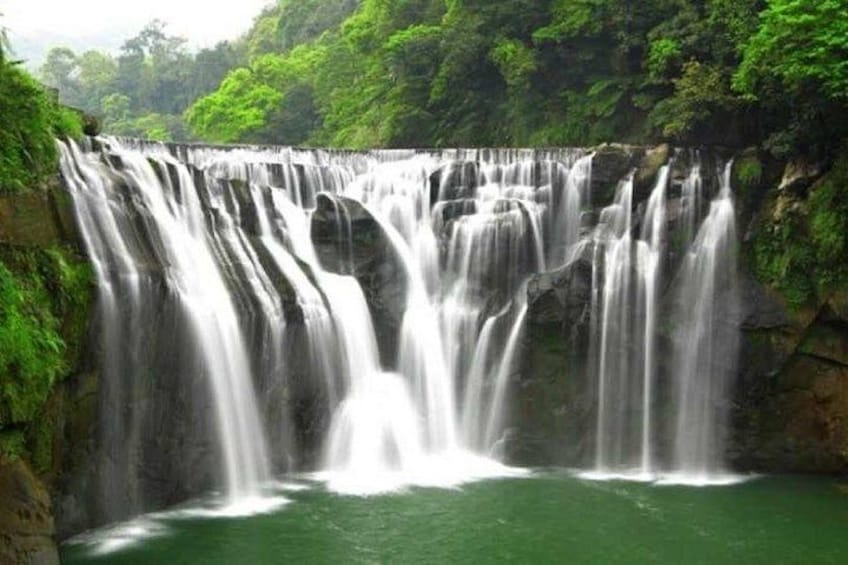 A multi-tiered waterfall surrounded by lush greenery. 2