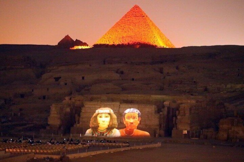The Great Pyramid of Giza with a large illuminated projection of a woman and a man in the foreground. 2