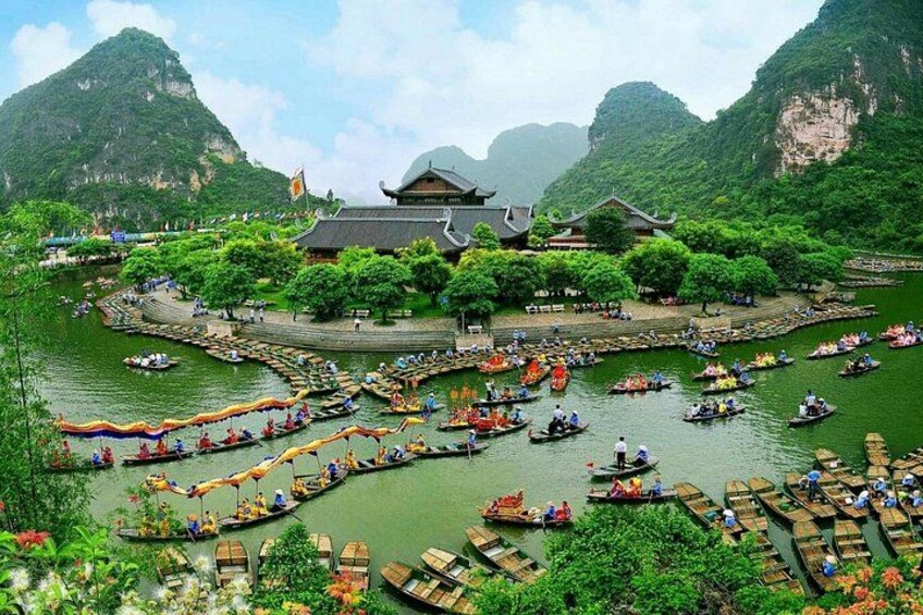 A traditional river scene with boats, a temple, and lush greenery. 3