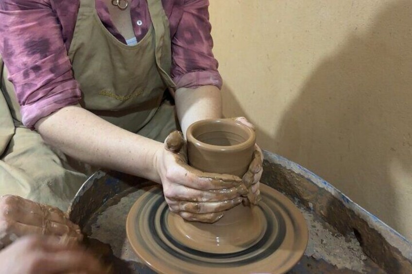 Una persona modella un vaso su un tornio da ceramica. 5