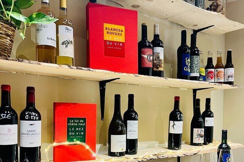 A wine shelf with various bottles and a red box labeled 'BLANCAS ROUGES'. 3
